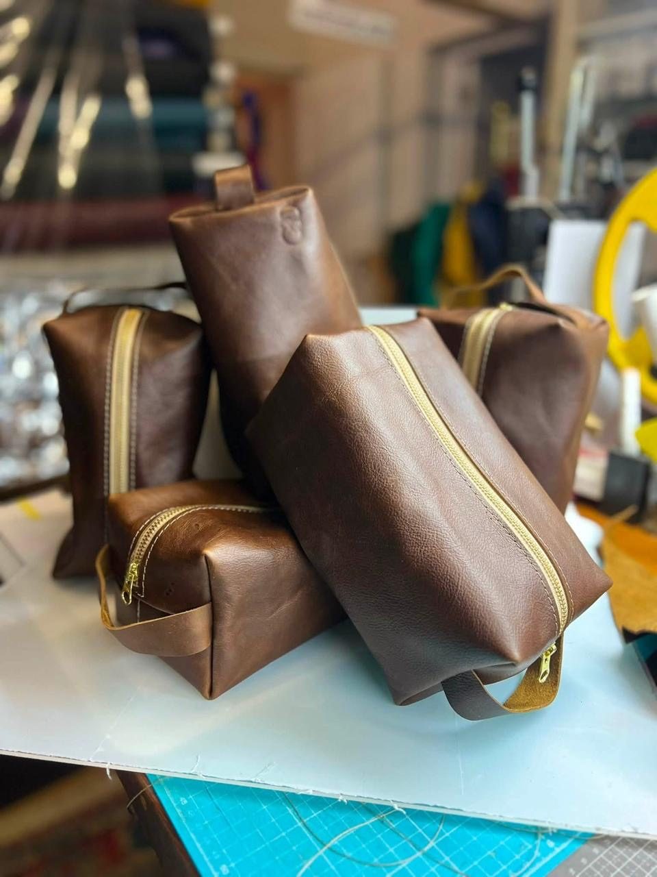 A pile of brown leather Dopp kits