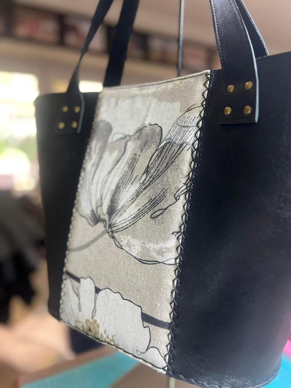 Close-up of a linen floral panel on a black tote